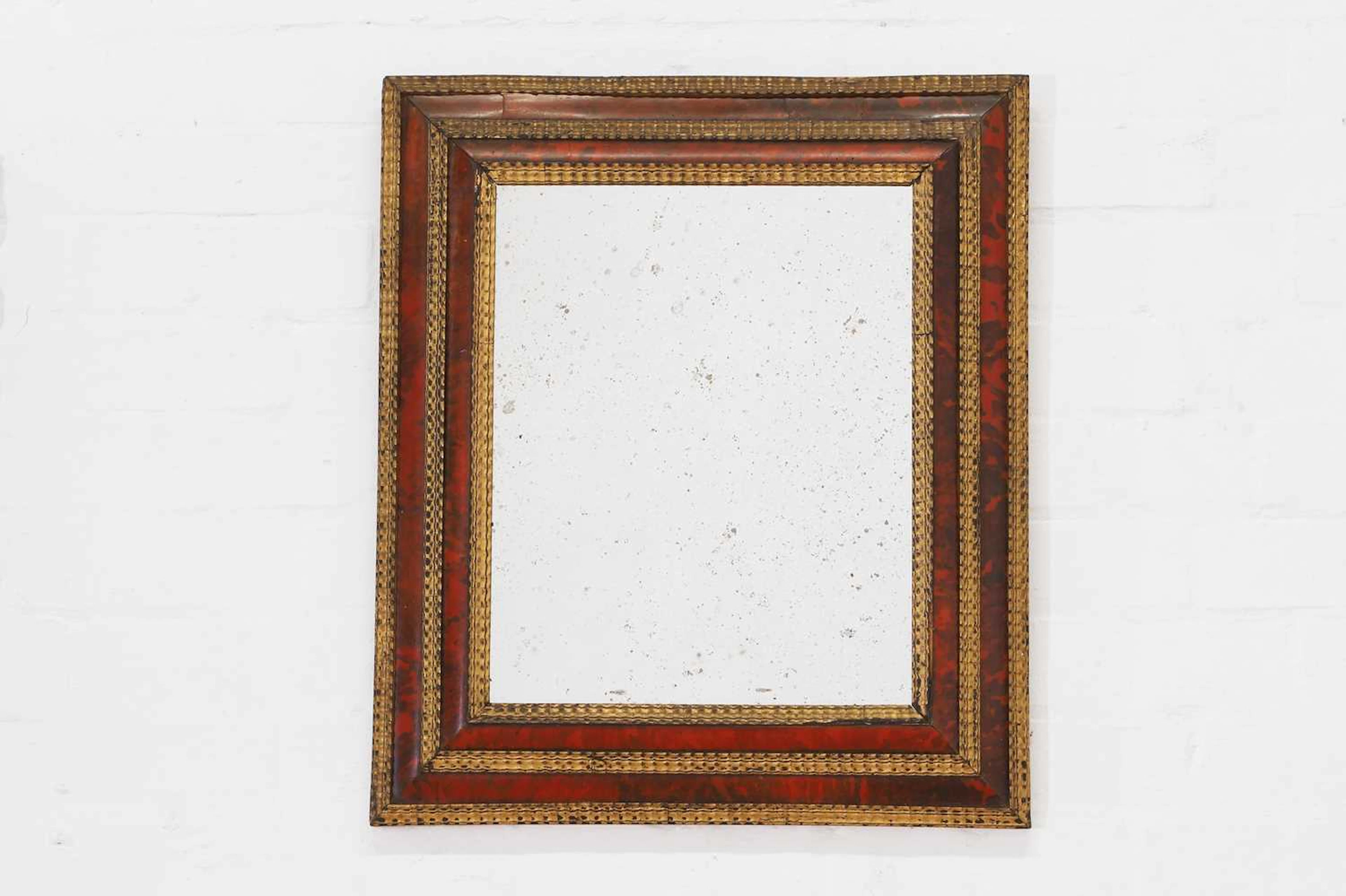 A baroque-style tortoiseshell and parcel-gilt wooden mirror