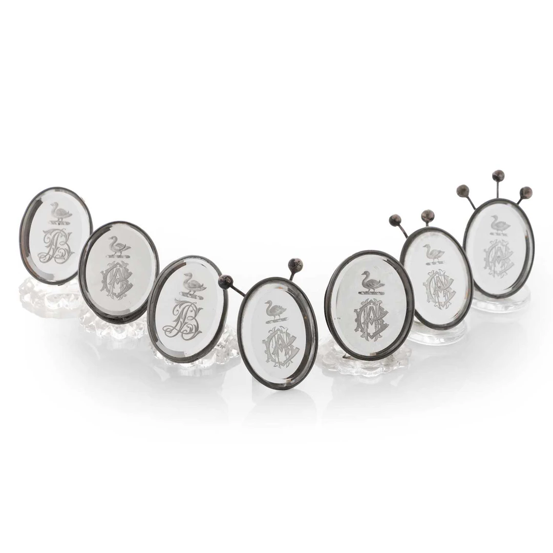 A composed set of seven reverse-engraved and mirrored-glass menu holders