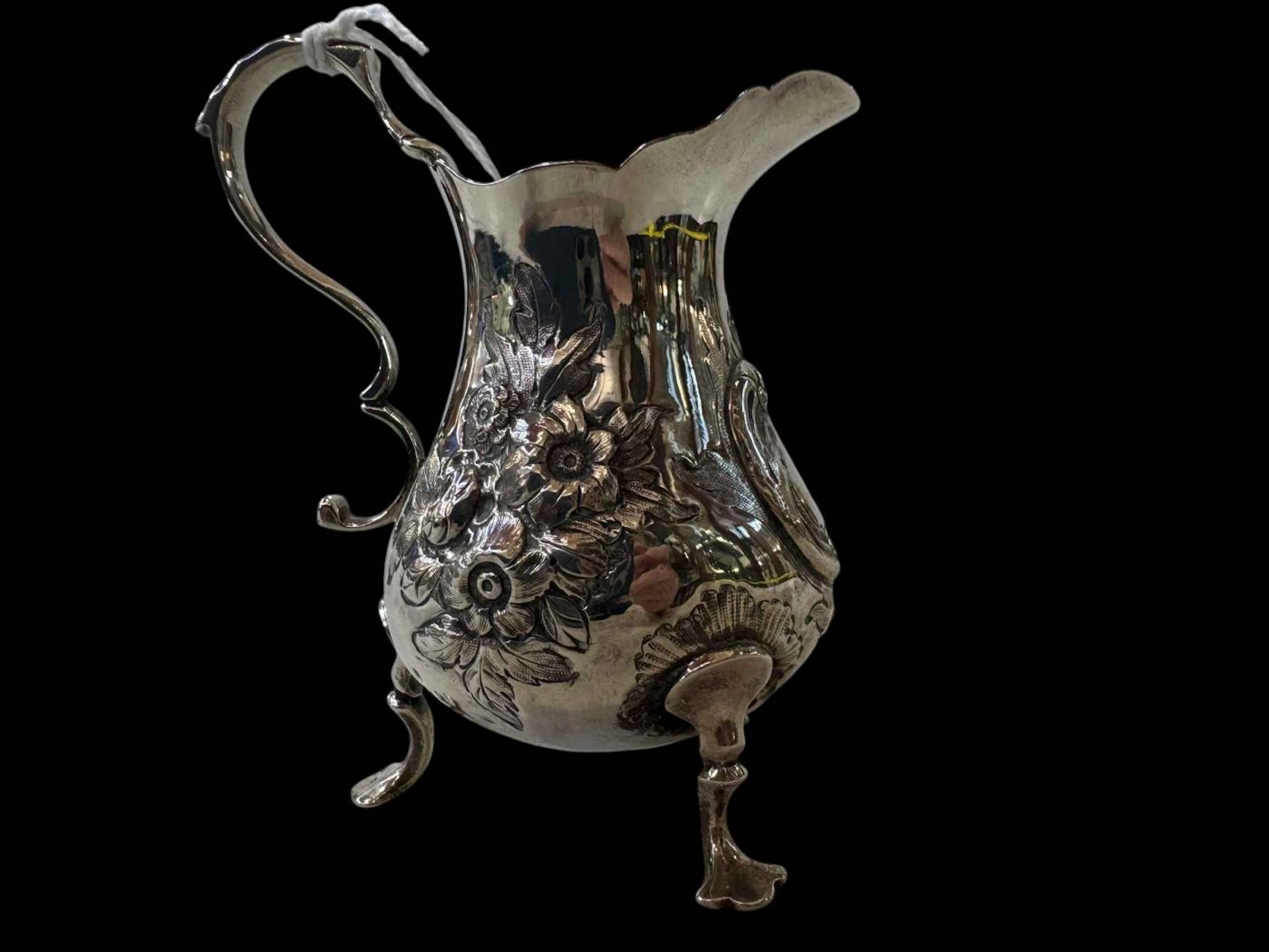 Victorian silver cream jug with embossed and chased decoration, London 1863.