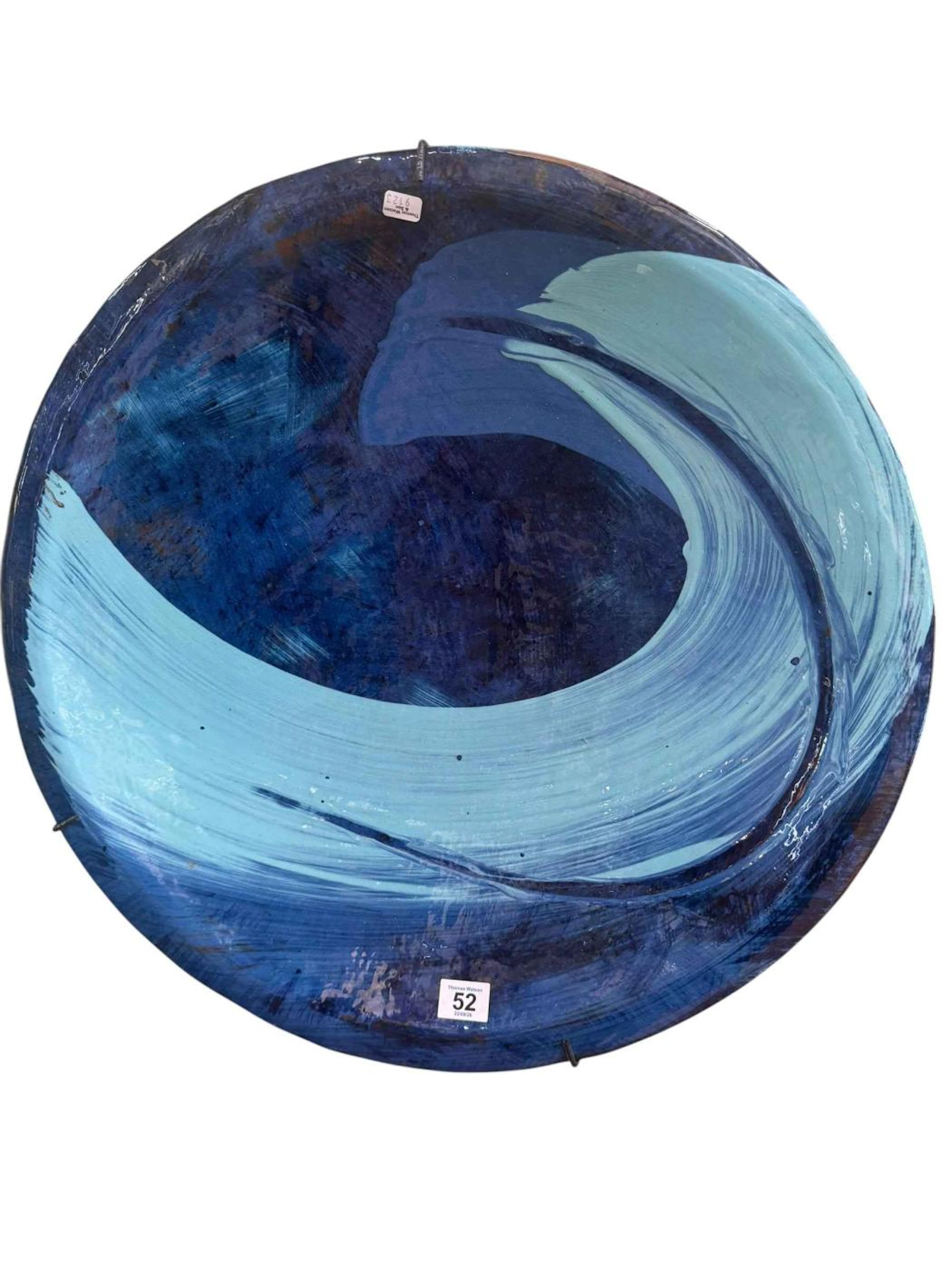 Large decorative ceramic charger featuring a wave pattern.