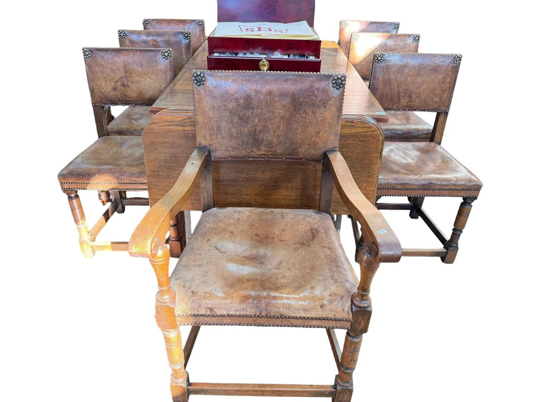 Carved oak extending dining table together with seven brass studded