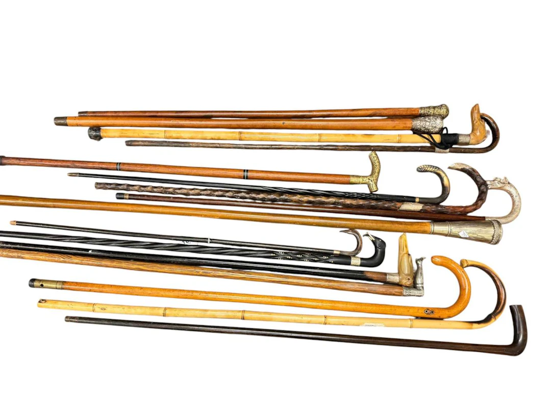 Collection of walking sticks including silver collared dog and elephant
