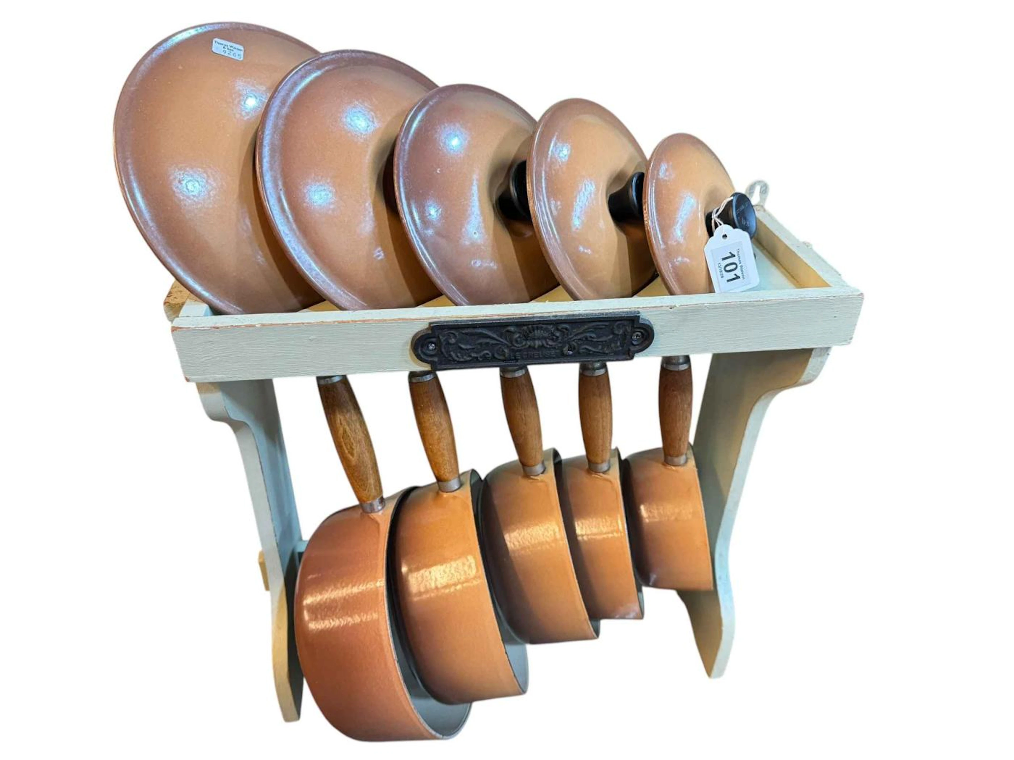 Set of five Le Creuset graduated sauce pans, lids and stand.