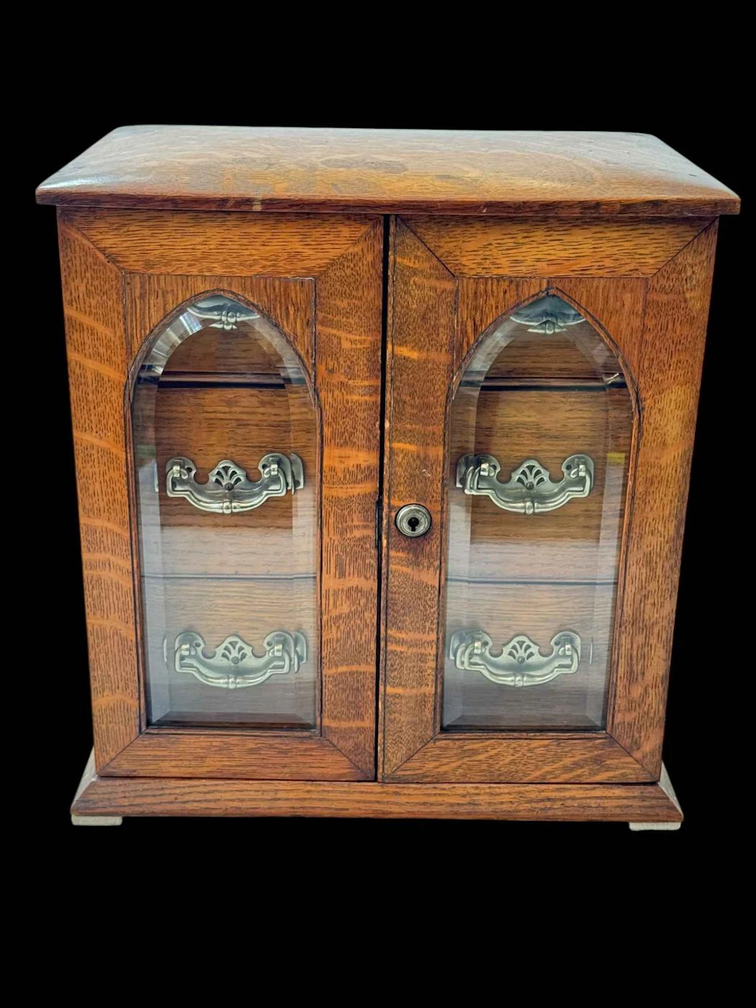 Late Victorian oak table cabinet of four drawers behind bevelled glass