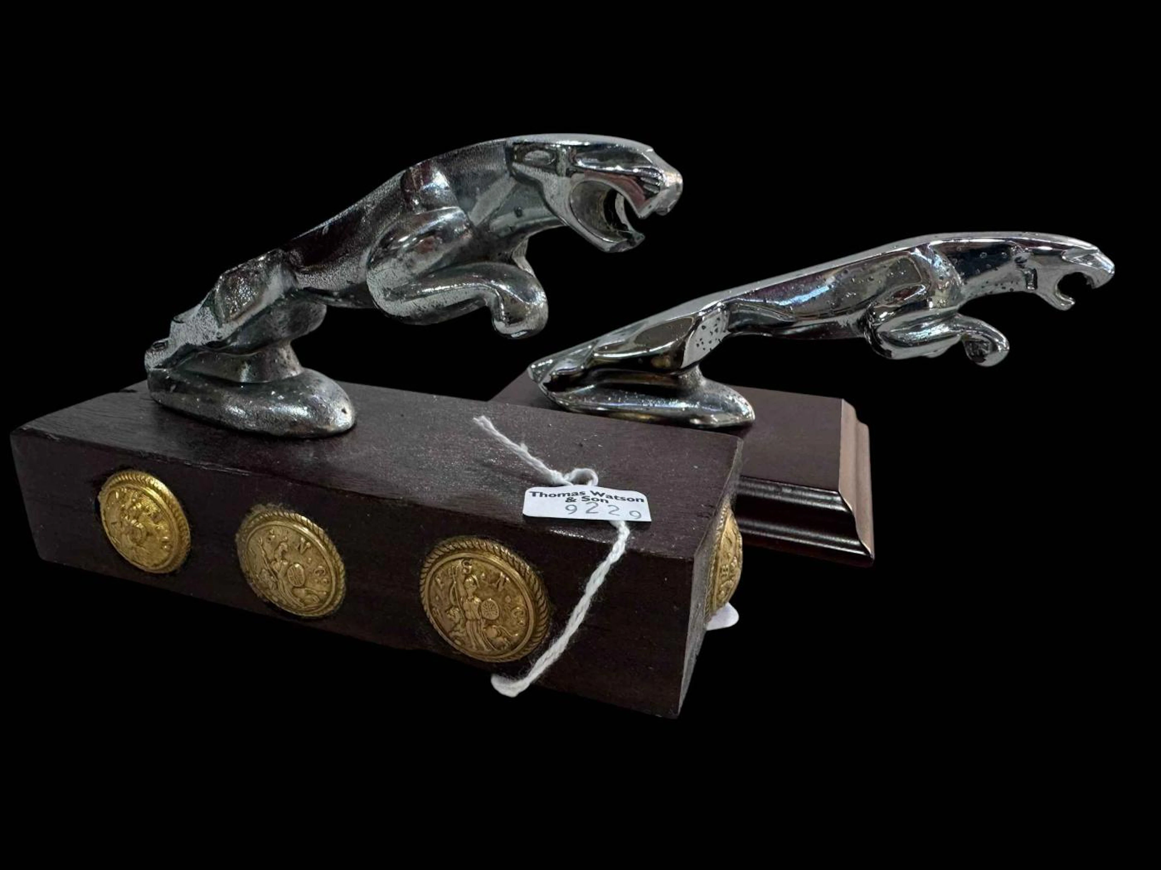 Two Jaguar car mascots.