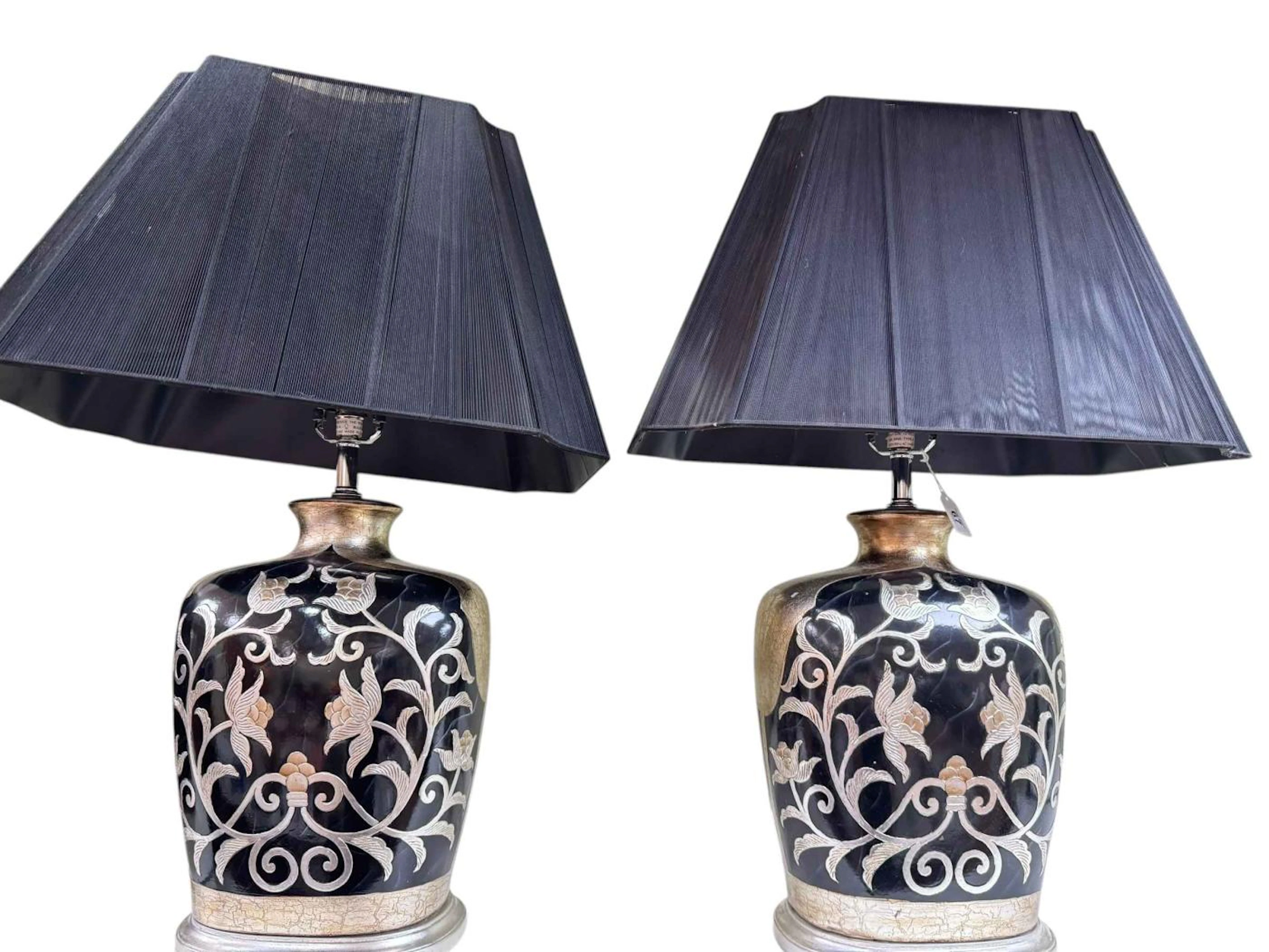 Pair of black and silver floral decorated table lamps and shades.