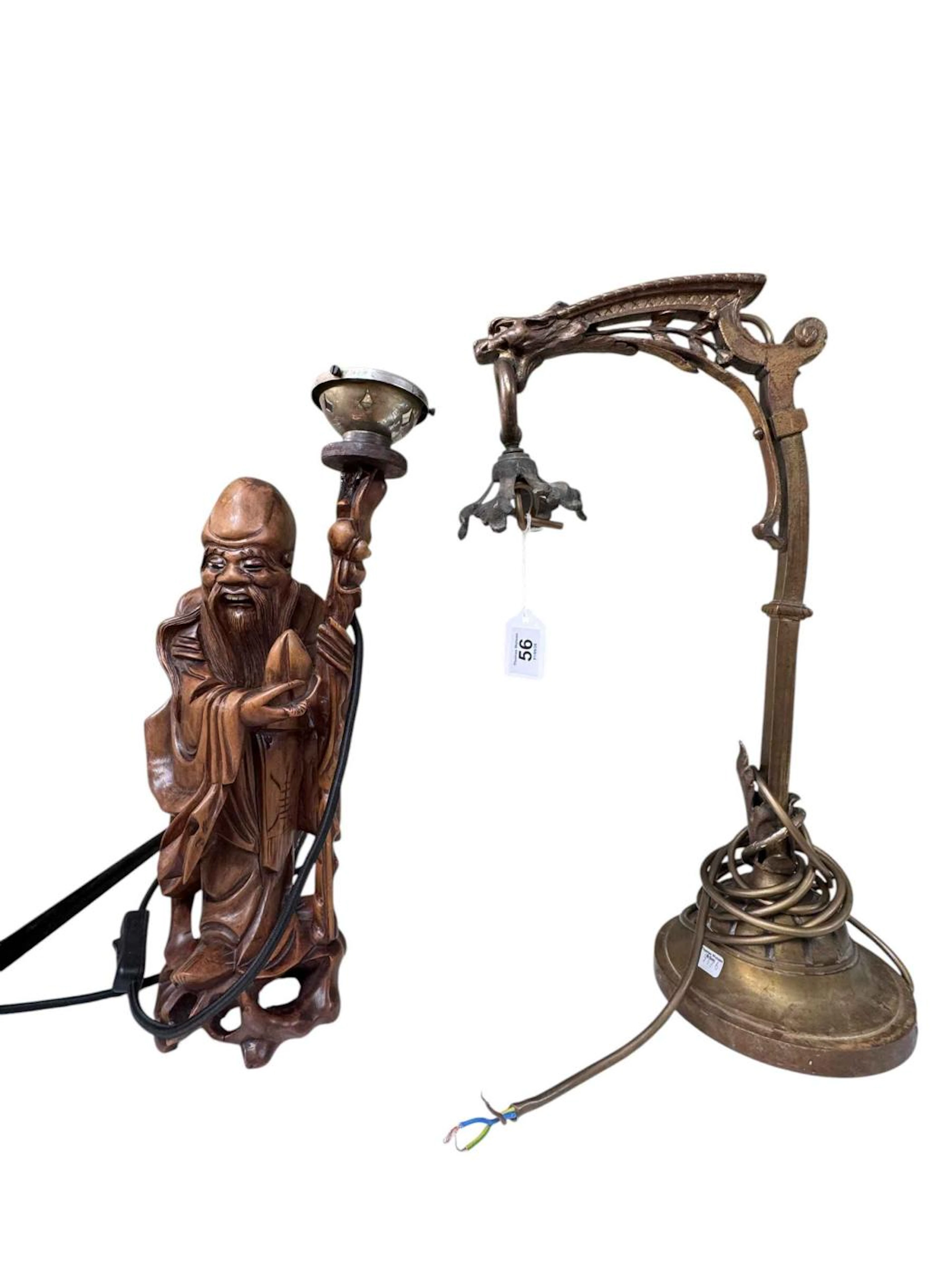 An Oriental carved wood figure lamp base and a Chinese brass lamp base.