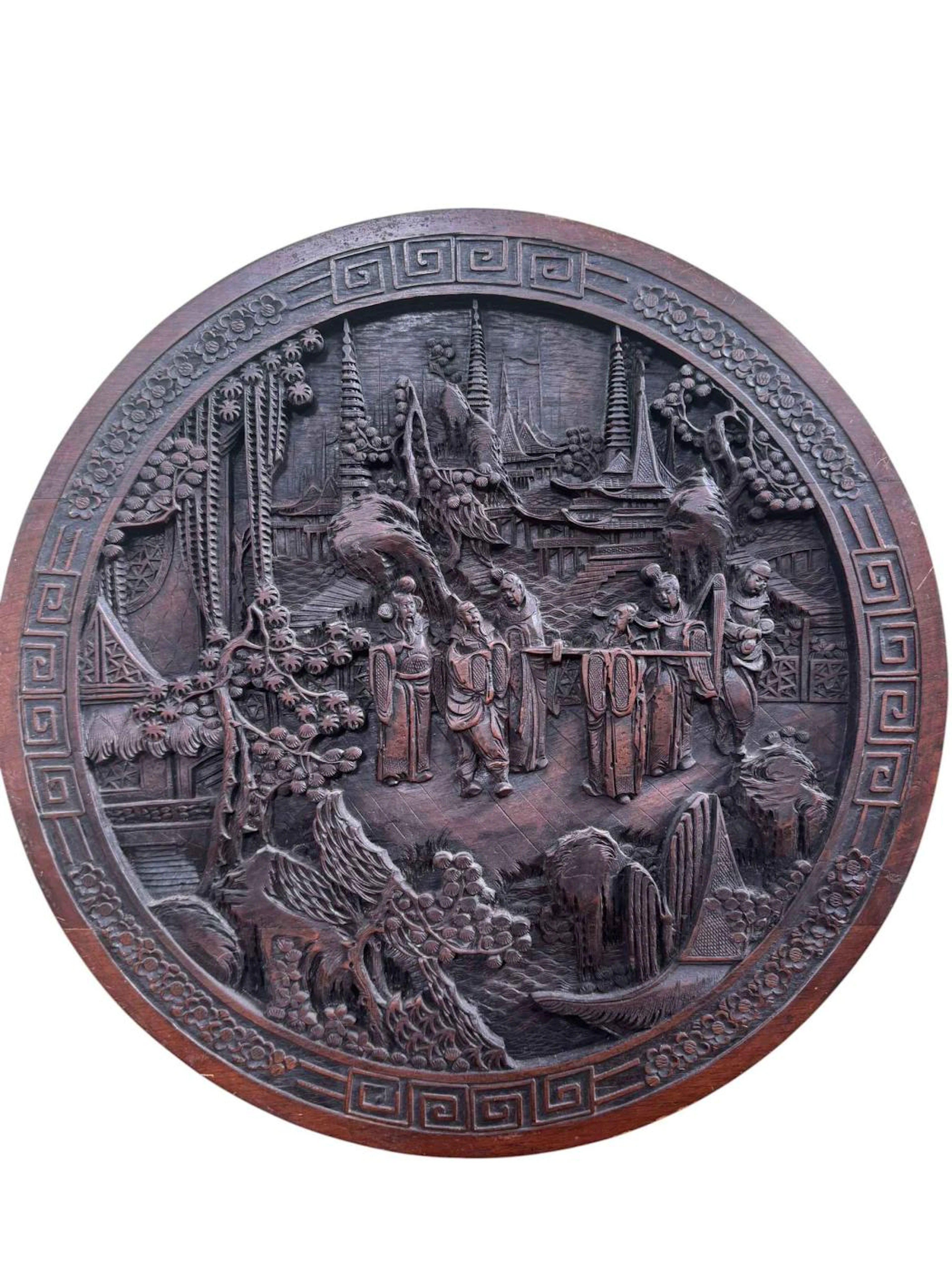 Large Chinese carved rosewood or teak high relief panel, 61cm diameter.