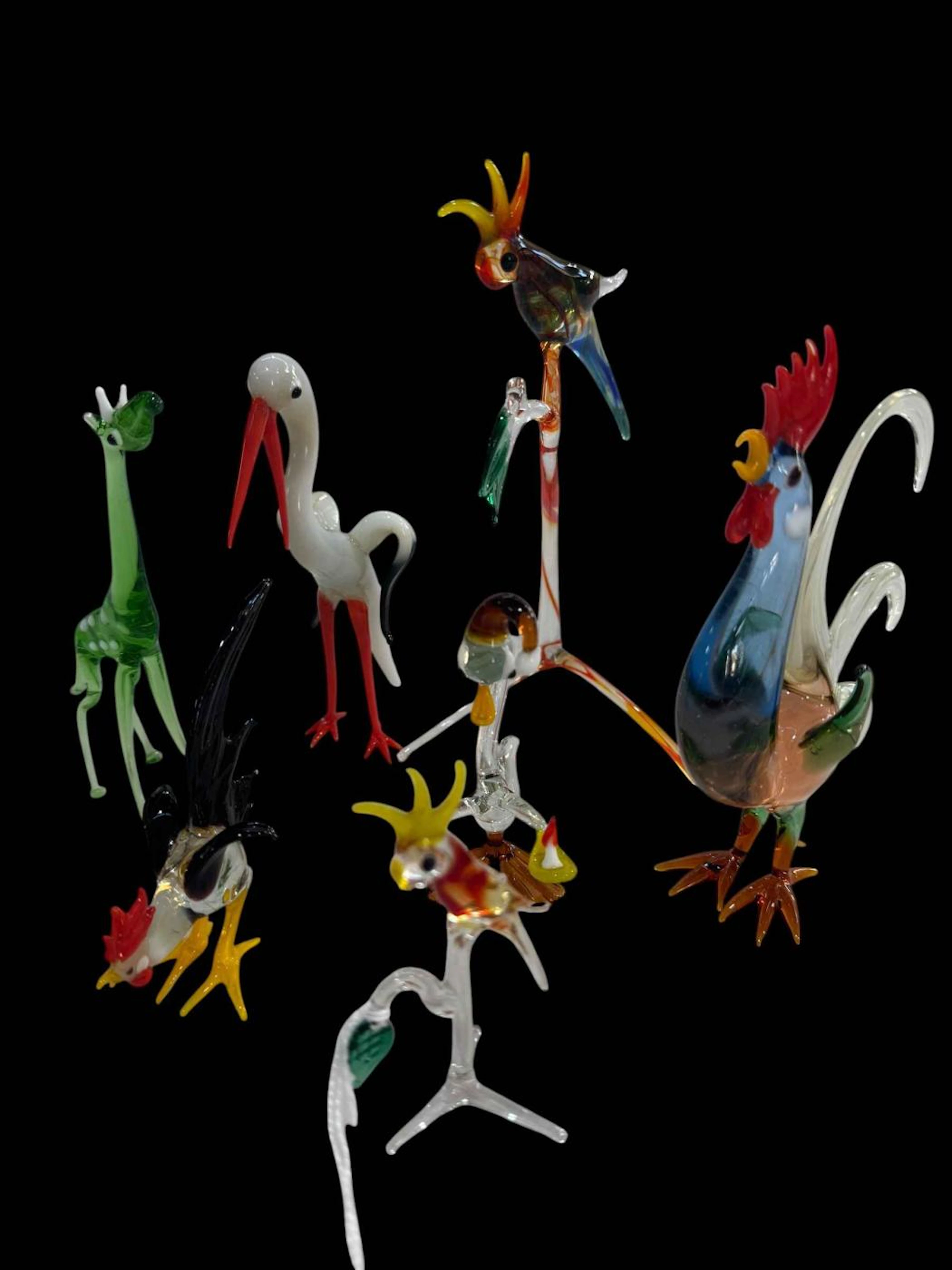 Seven small glass birds and giraffe.