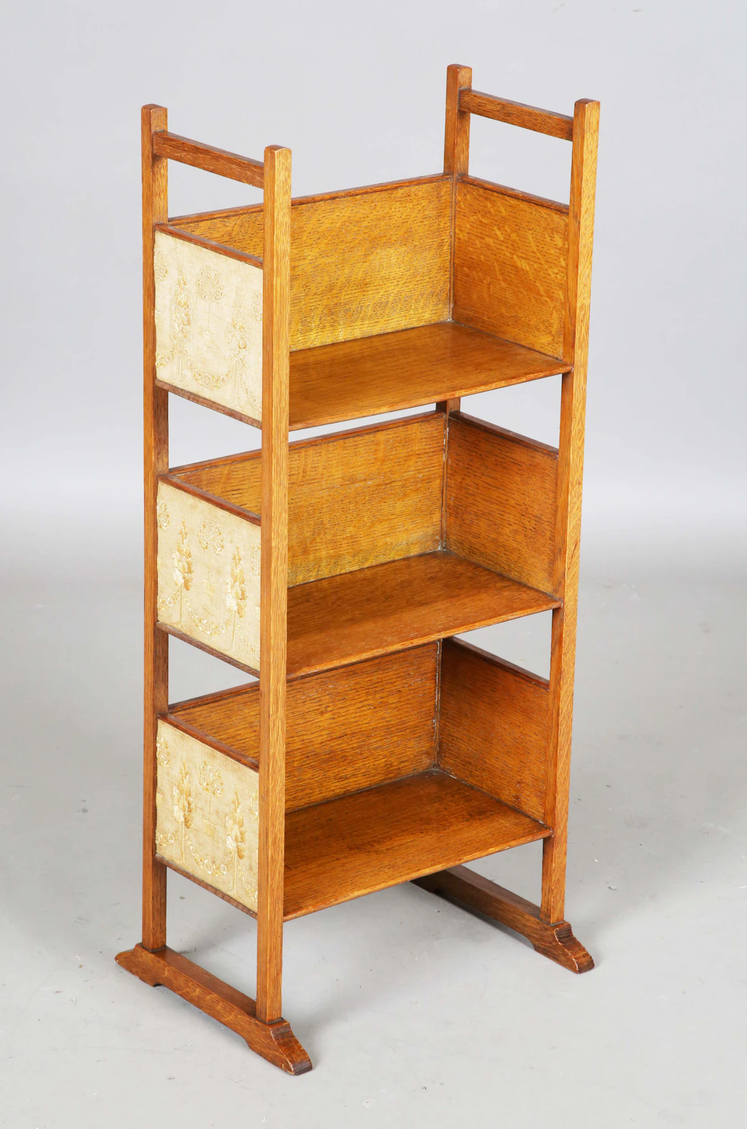 A small Edwardian Arts and Crafts oak framed open bookshelf, in the
