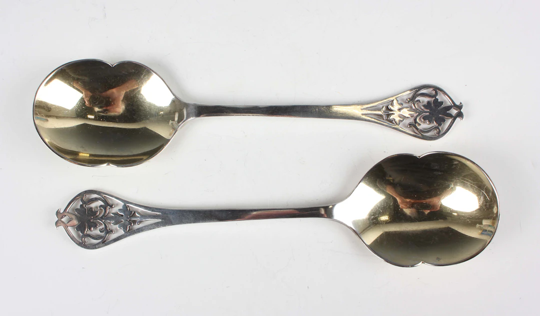 A pair of George VI silver serving spoons, each tapering handle pierced