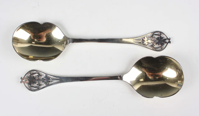 A pair of George VI silver serving spoons, each tapering handle pierced