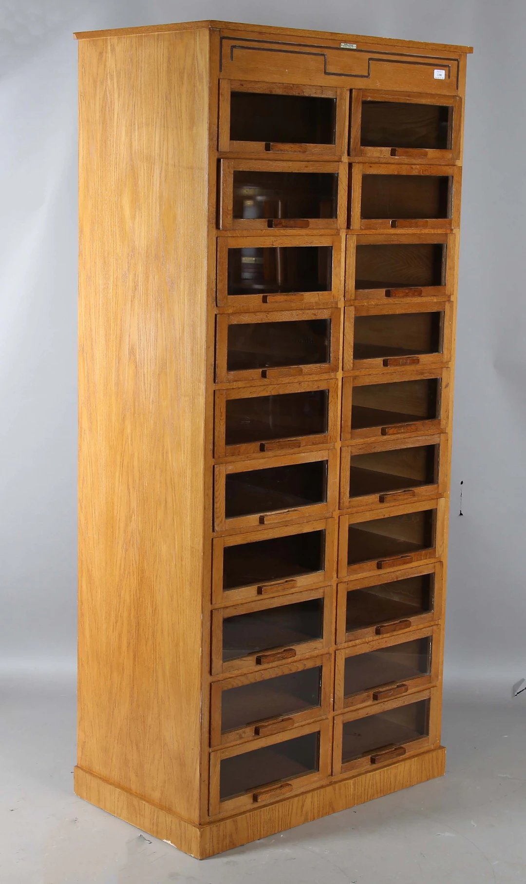 An Art Deco oak haberdashery cabinet by Dudley & Co Ltd, London, fitted