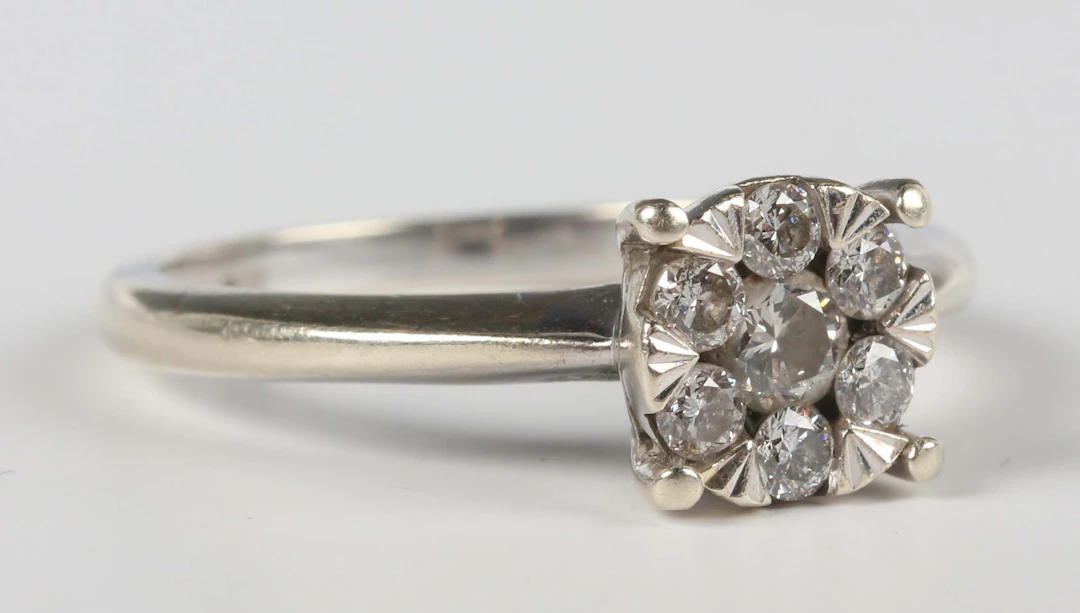 A 9ct white gold and diamond seven stone cluster ring, mounted with