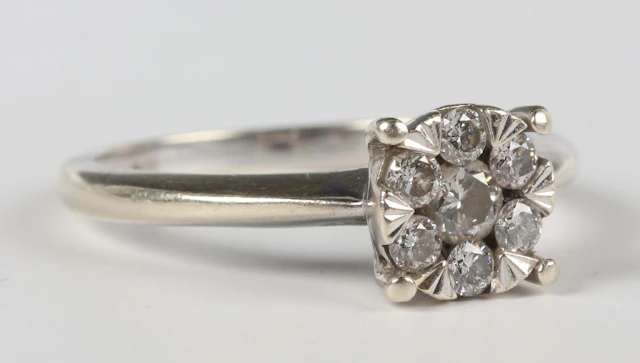 A 9ct white gold and diamond seven stone cluster ring, mounted with
