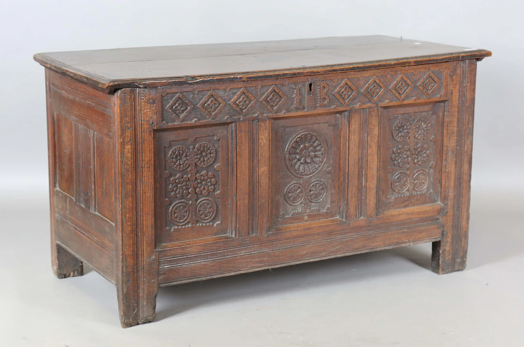 A late 17th century oak panelled coffer, the front with carved decoration