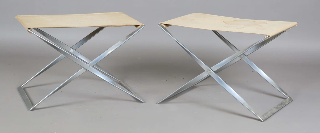 A pair of brushed steel PK91 model folding stools, designed by Poul