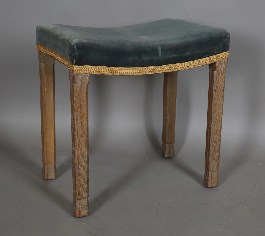 An Elizabeth II limed oak coronation stool with blue velvet seat
