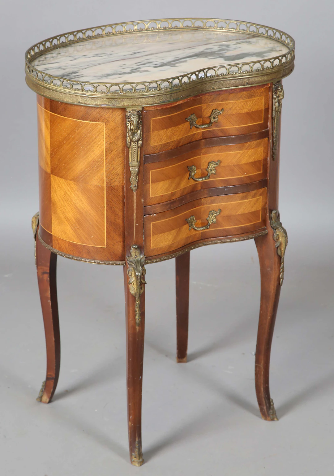 A 20th century French kingwood bedside chest of three drawers, inset