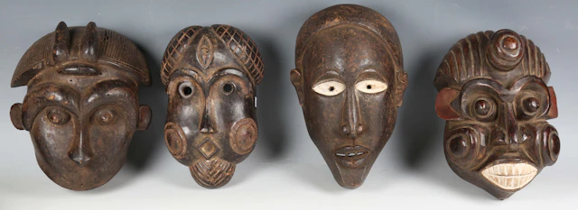 A group of four African carved and painted wooden masks of various