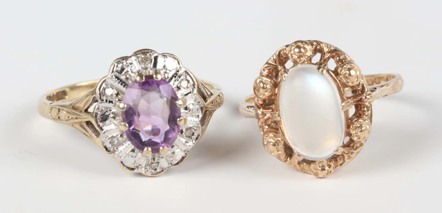 A 9ct gold ring, claw set with an oval moonstone within a floral surround
