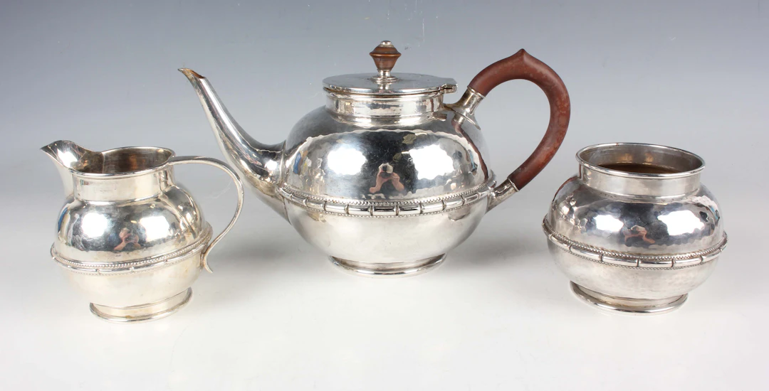 An Arts and Crafts style silver three-piece tea set of girdled globular
