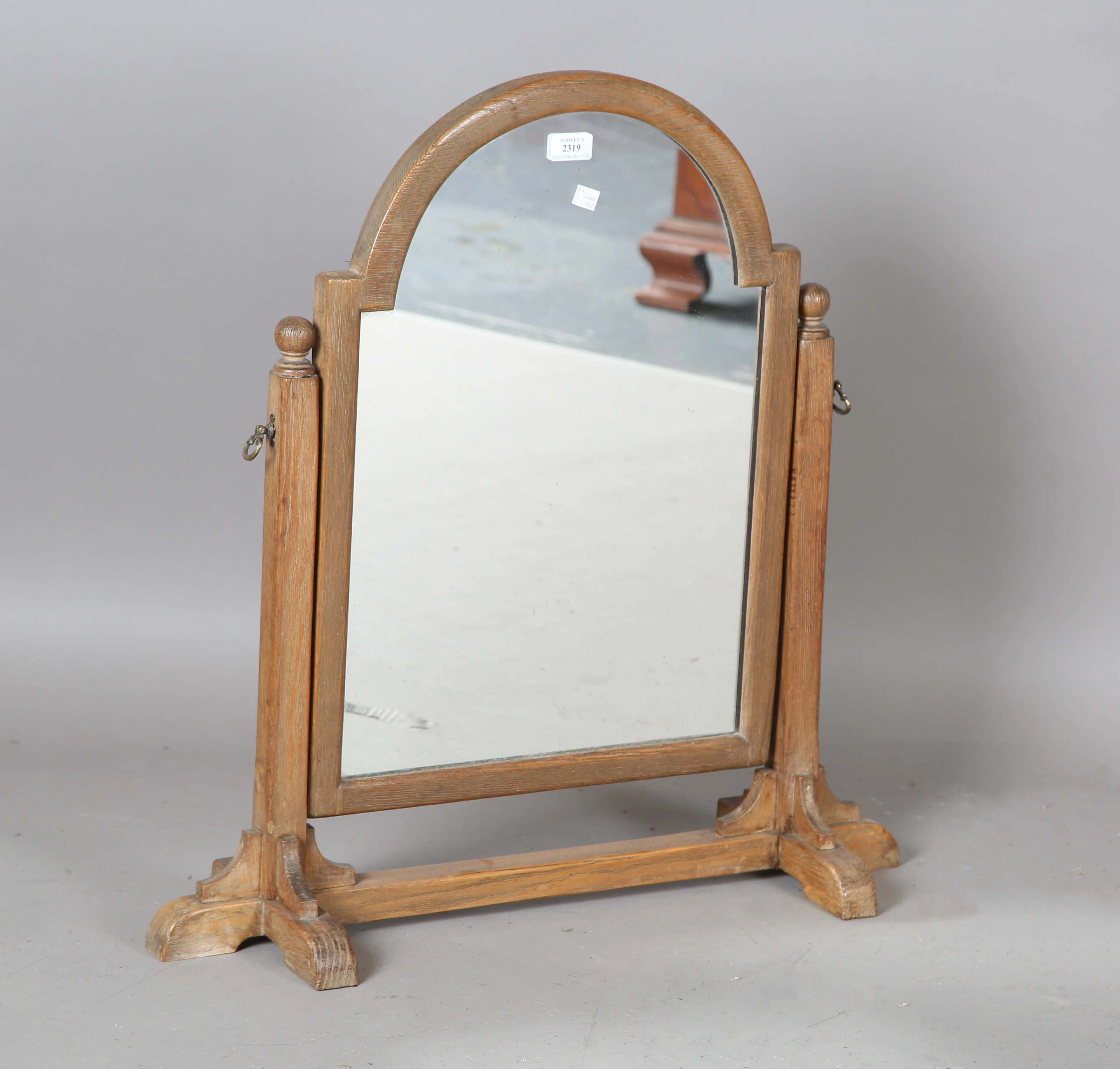 An early 20th century Arts and Crafts oak framed dressing table mirror