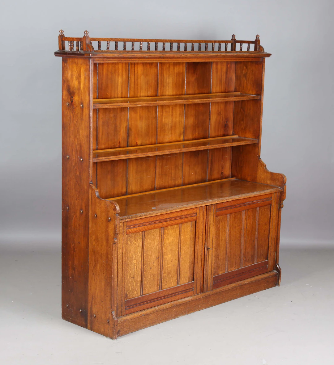 A late Victorian Aesthetic Movement oak bookcase, the balustrade gallery