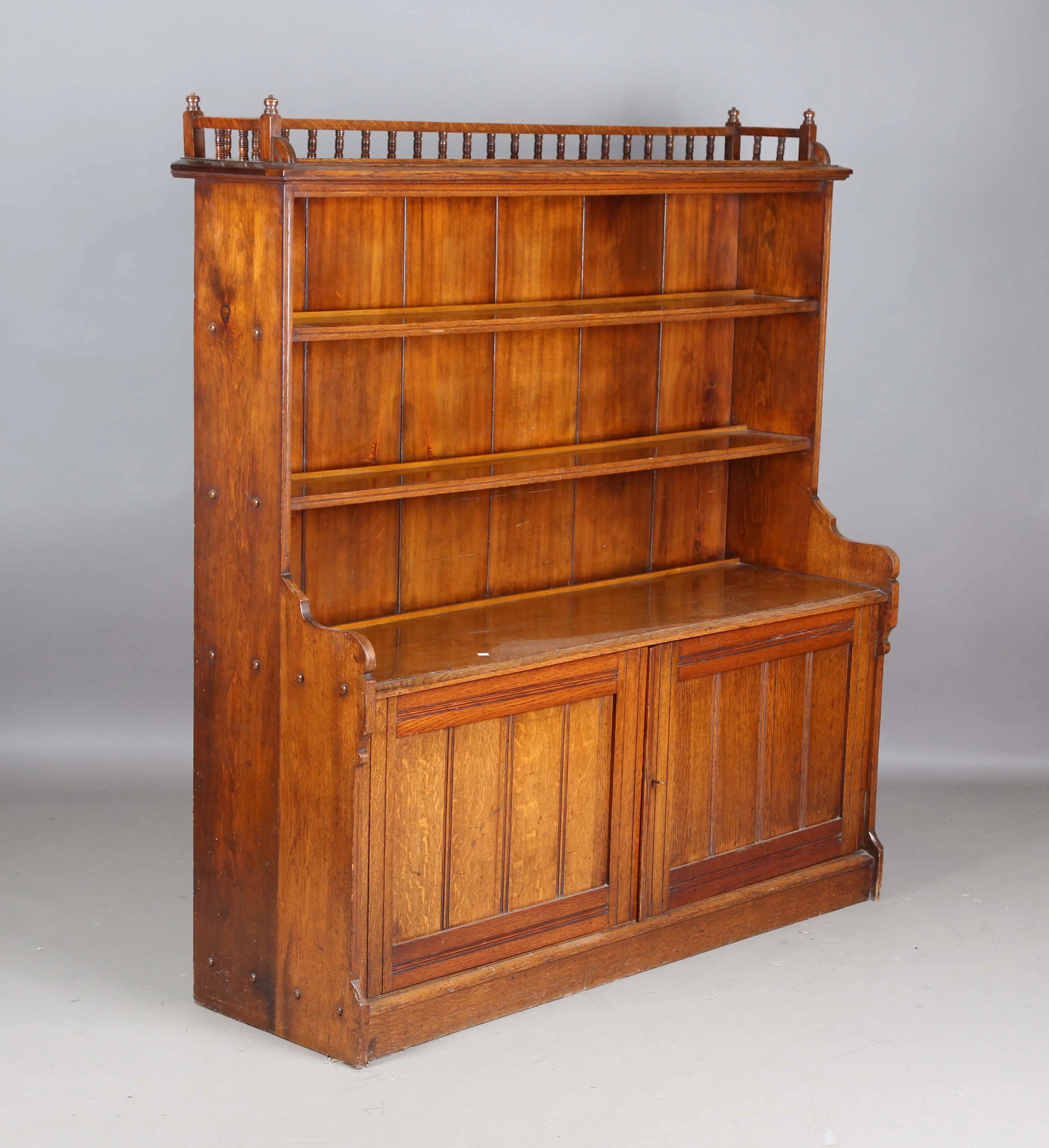 A late Victorian Aesthetic Movement oak bookcase, the balustrade gallery