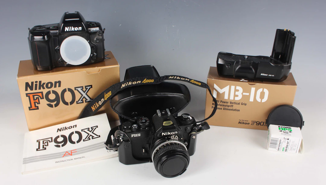 A Nikon FM2 camera with Nikkor 50mm 1:1.8 lens, a Nikon F90X camera