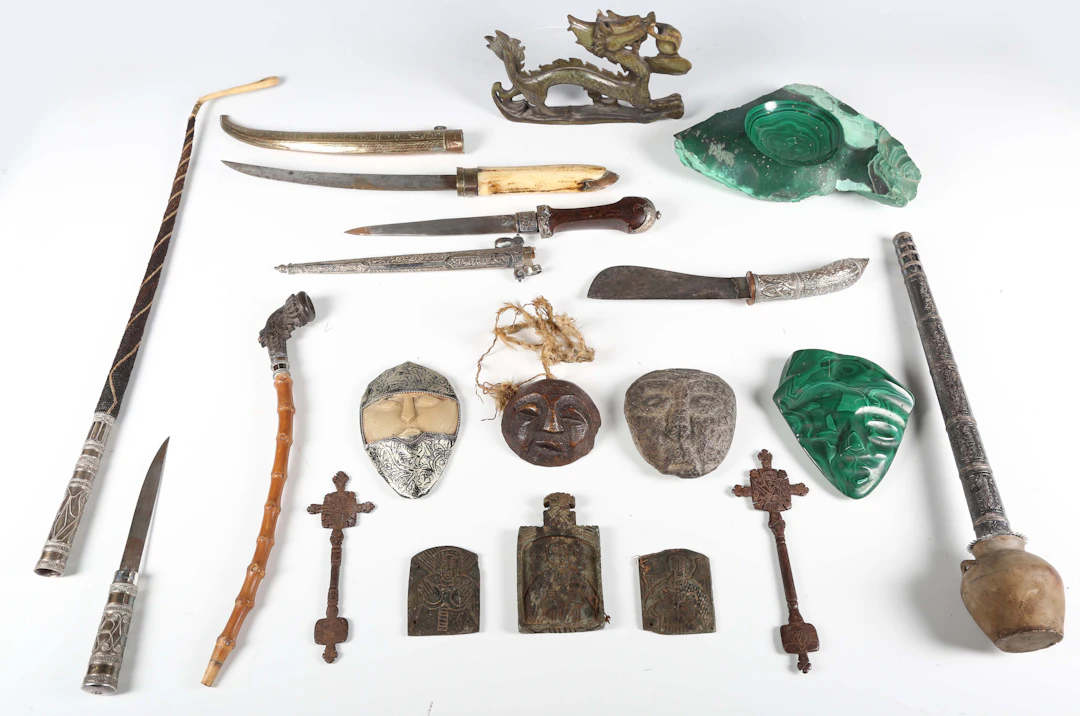 A mixed group of ethnic items, including two carved masks, two daggers