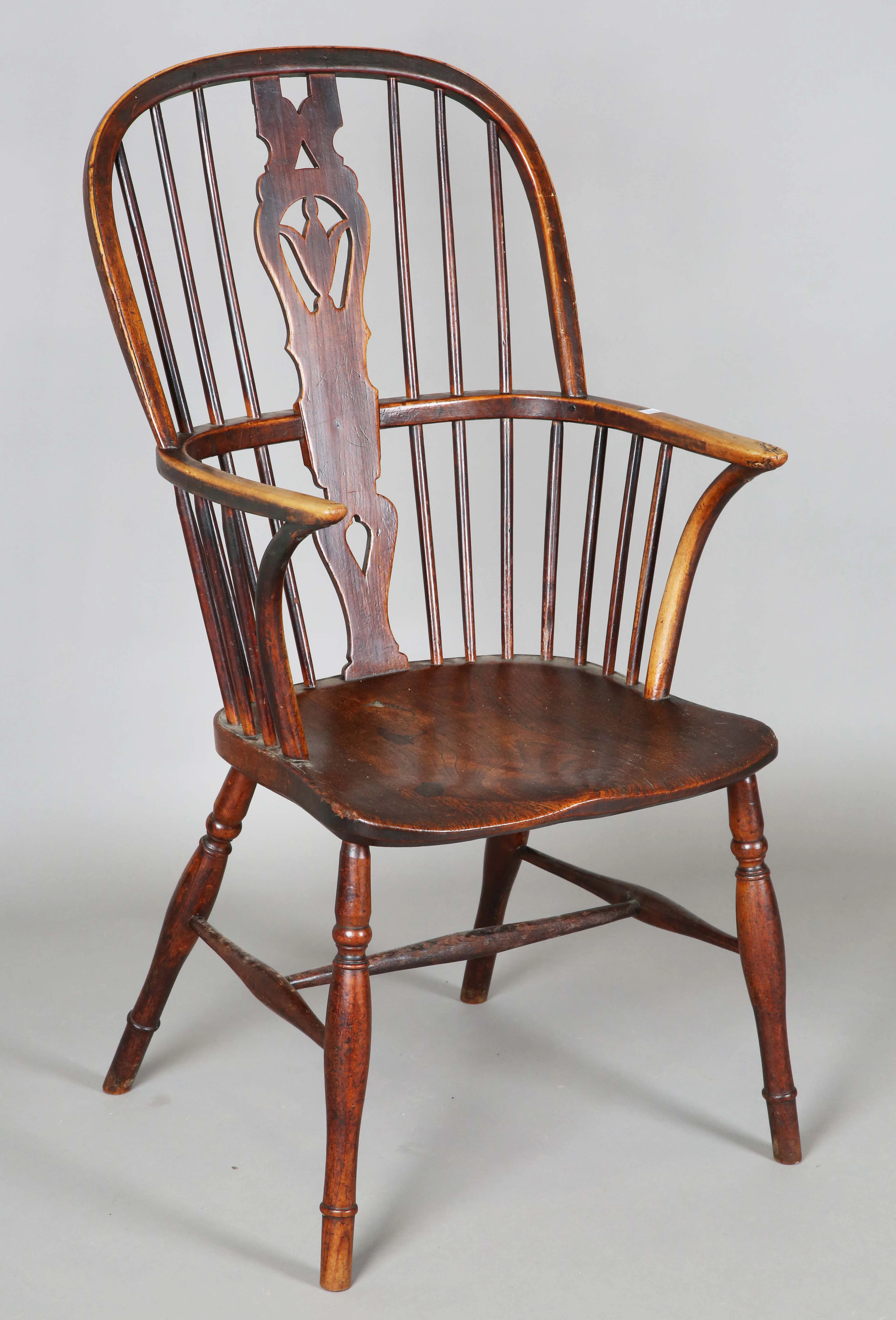 A mid-Victorian fruitwood and elm pierced splat back Windsor armchair