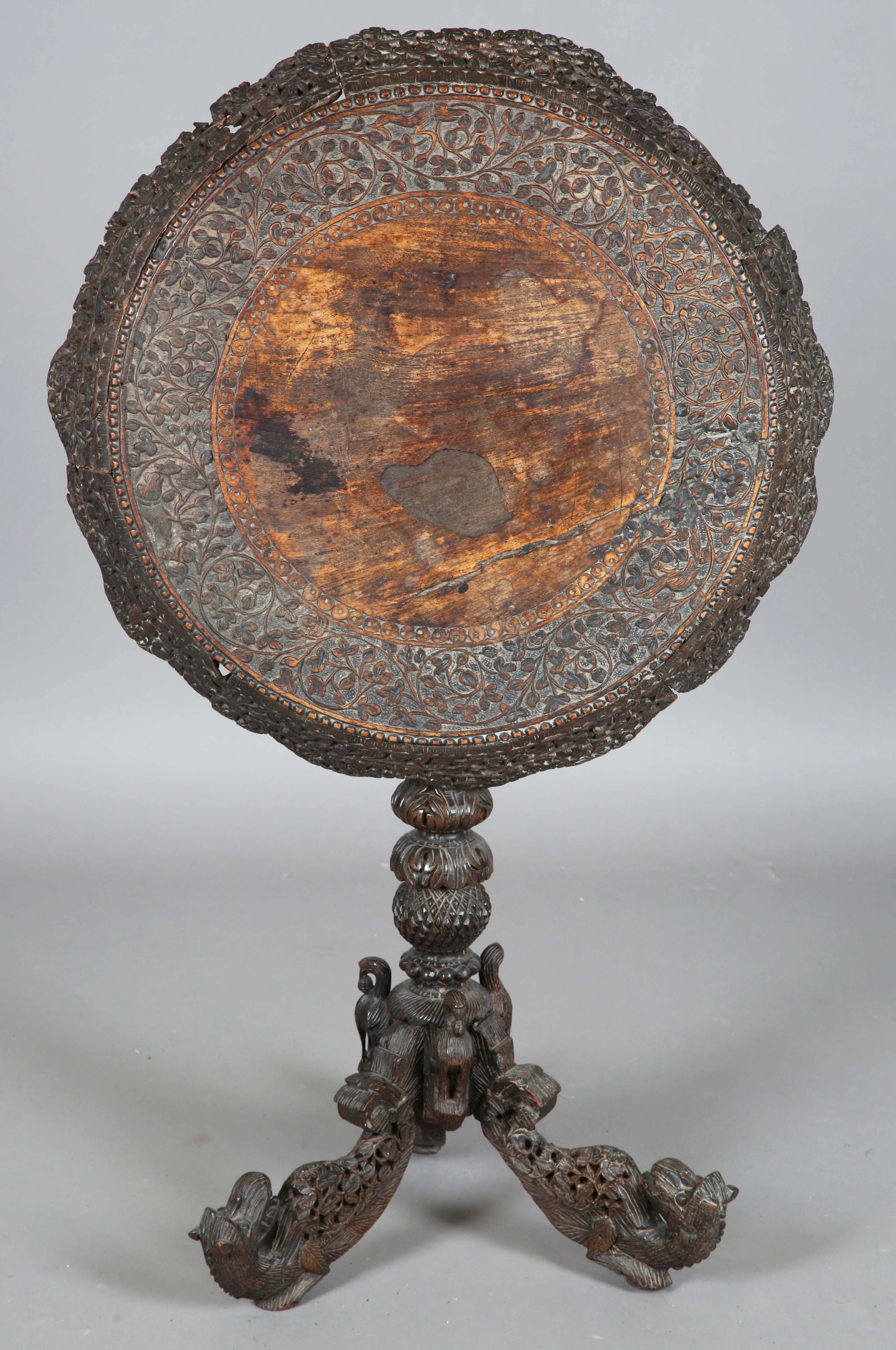 A 19th century Burmese carved and pierced circular wine table, profusely