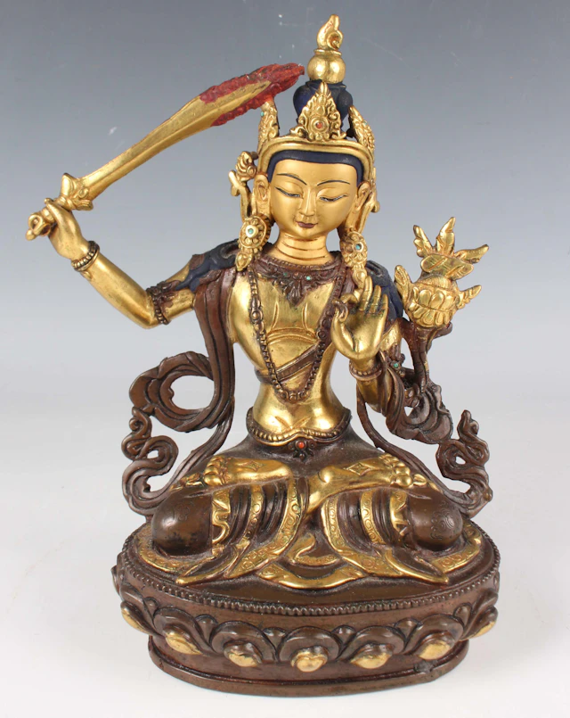 A Sino-Tibetan gilt and brown patinated bronze figure of Manjushri