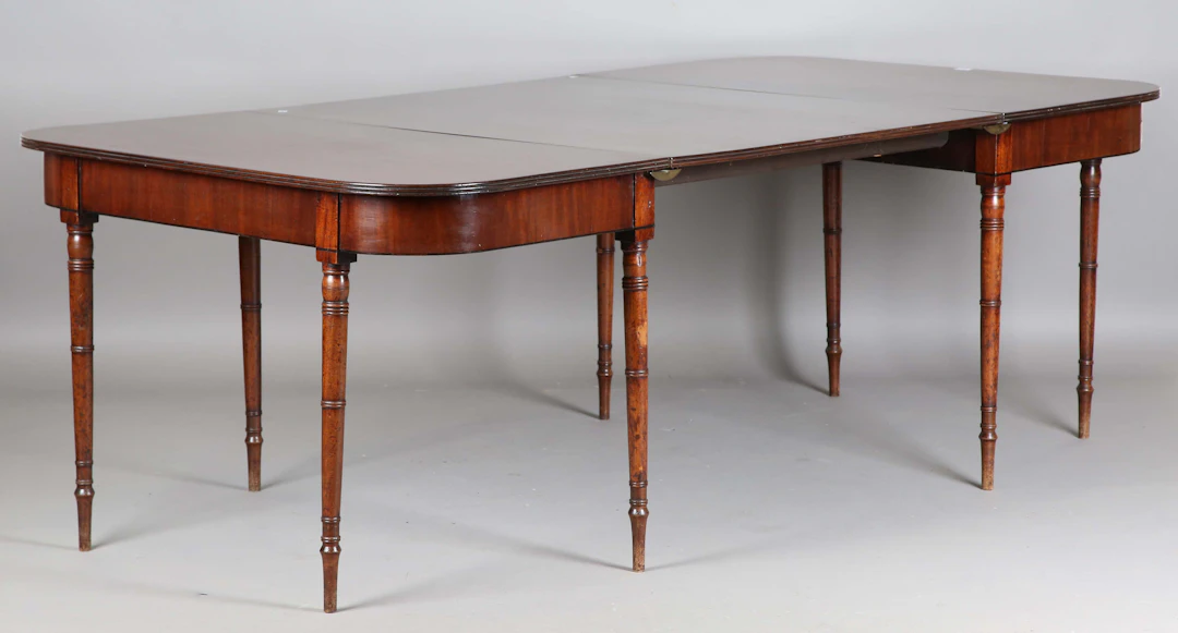 A George IV mahogany D-end dining table with a large single extra