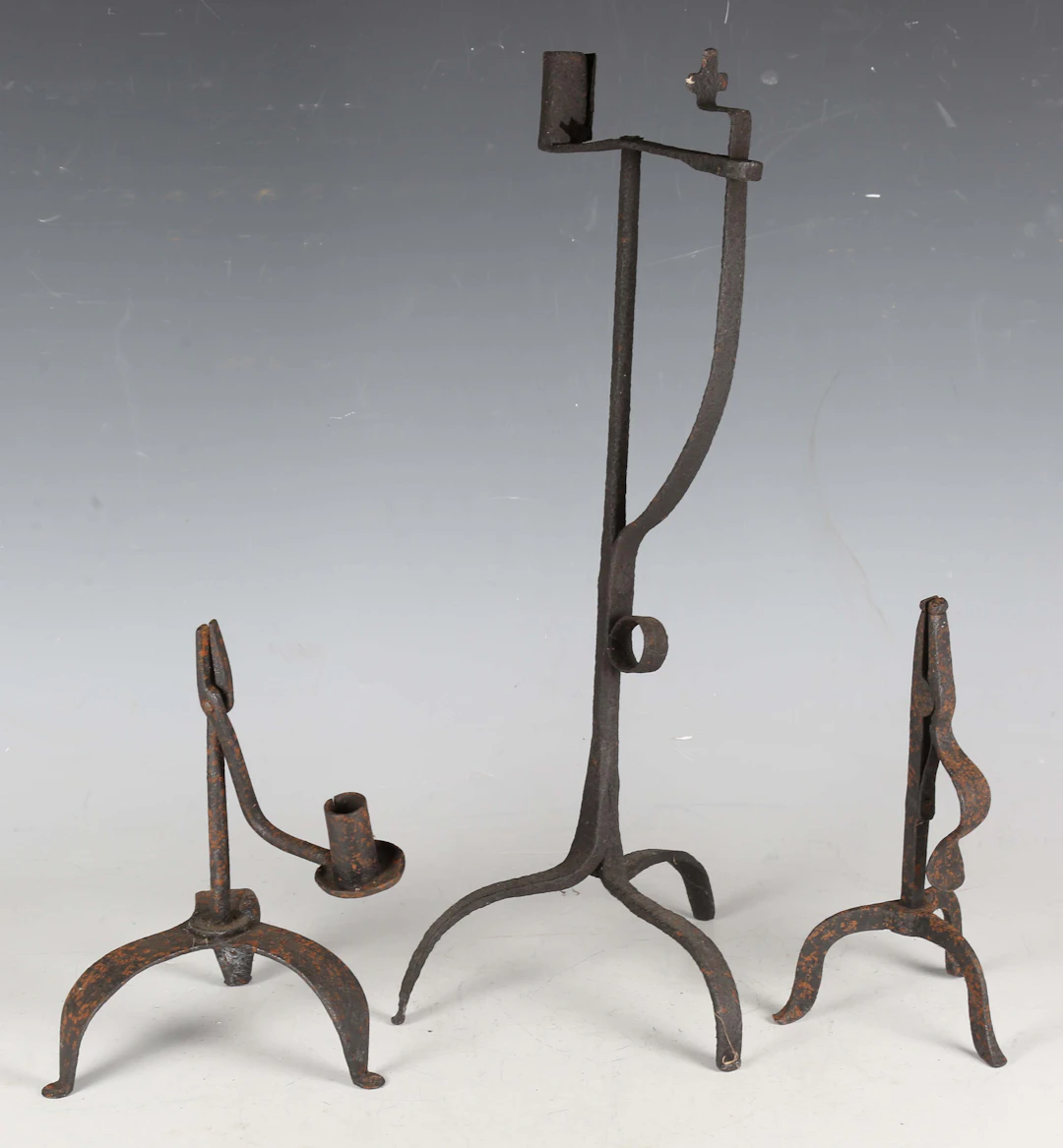 A 17th century wrought iron candle holder, on triform supports, height