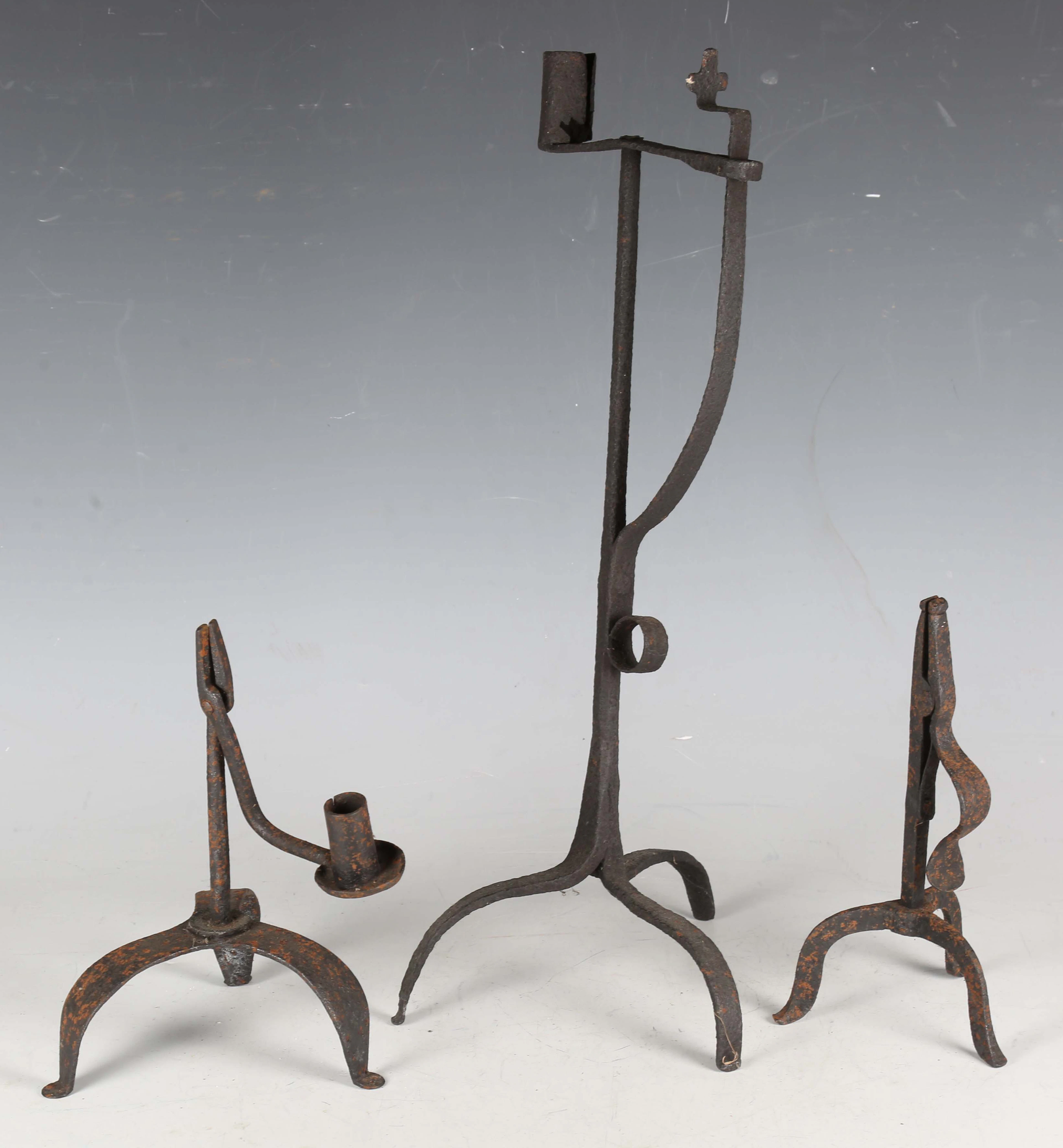 A 17th century wrought iron candle holder, on triform supports, height