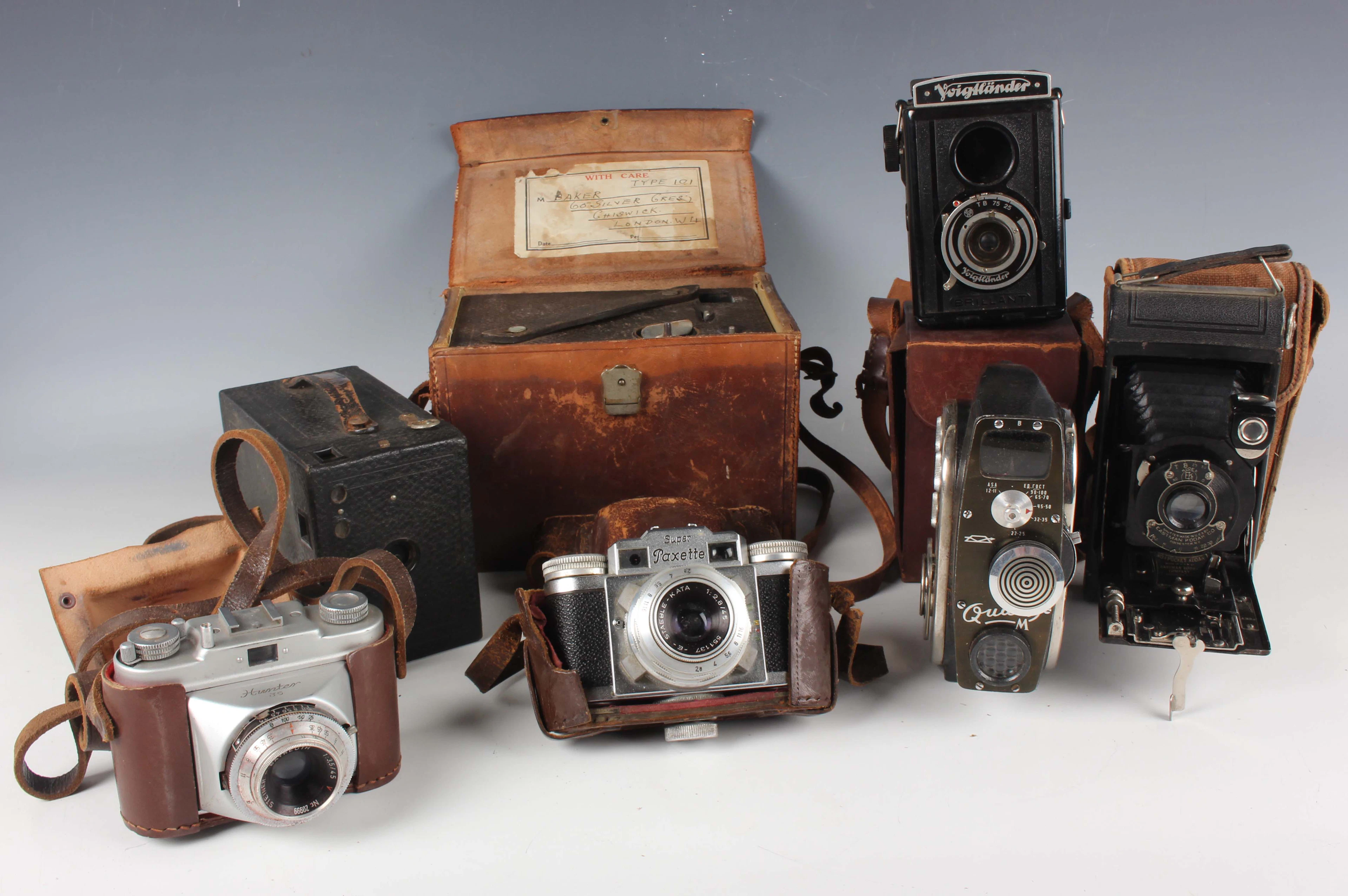 A group of assorted cameras and accessories, including a Braun Super