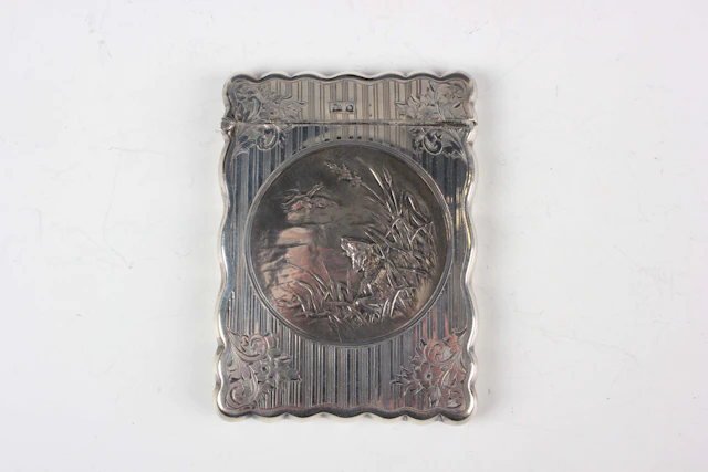 An Edwardian silver rectangular card case with shaped outline, the