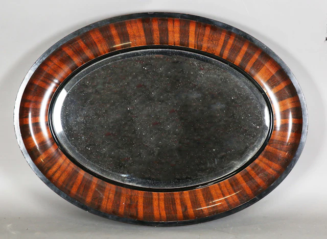 An early 20th century oval wall mirror with a bevelled glass plate