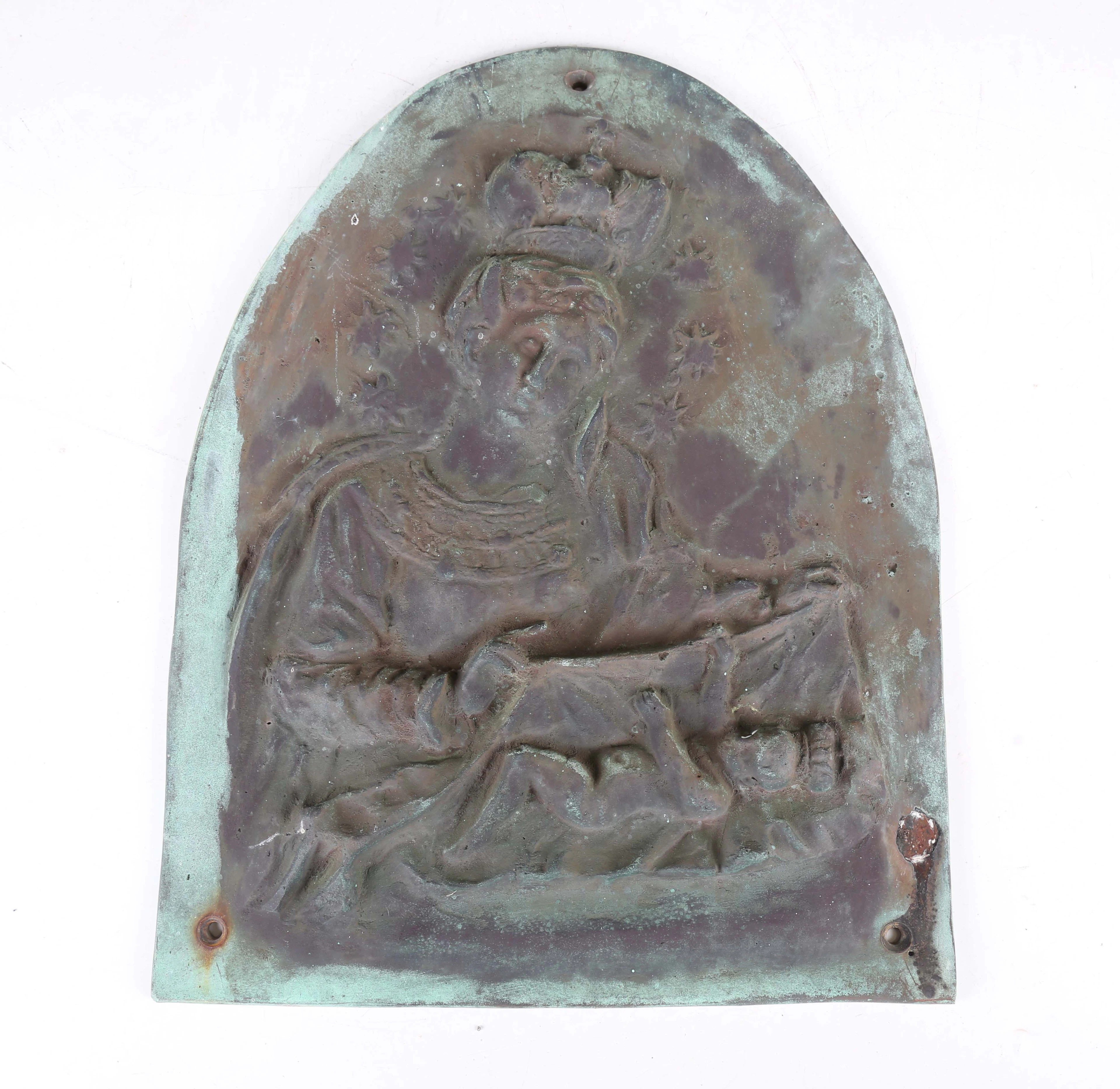 An 18th century green patinated cast metal plaque of arched form