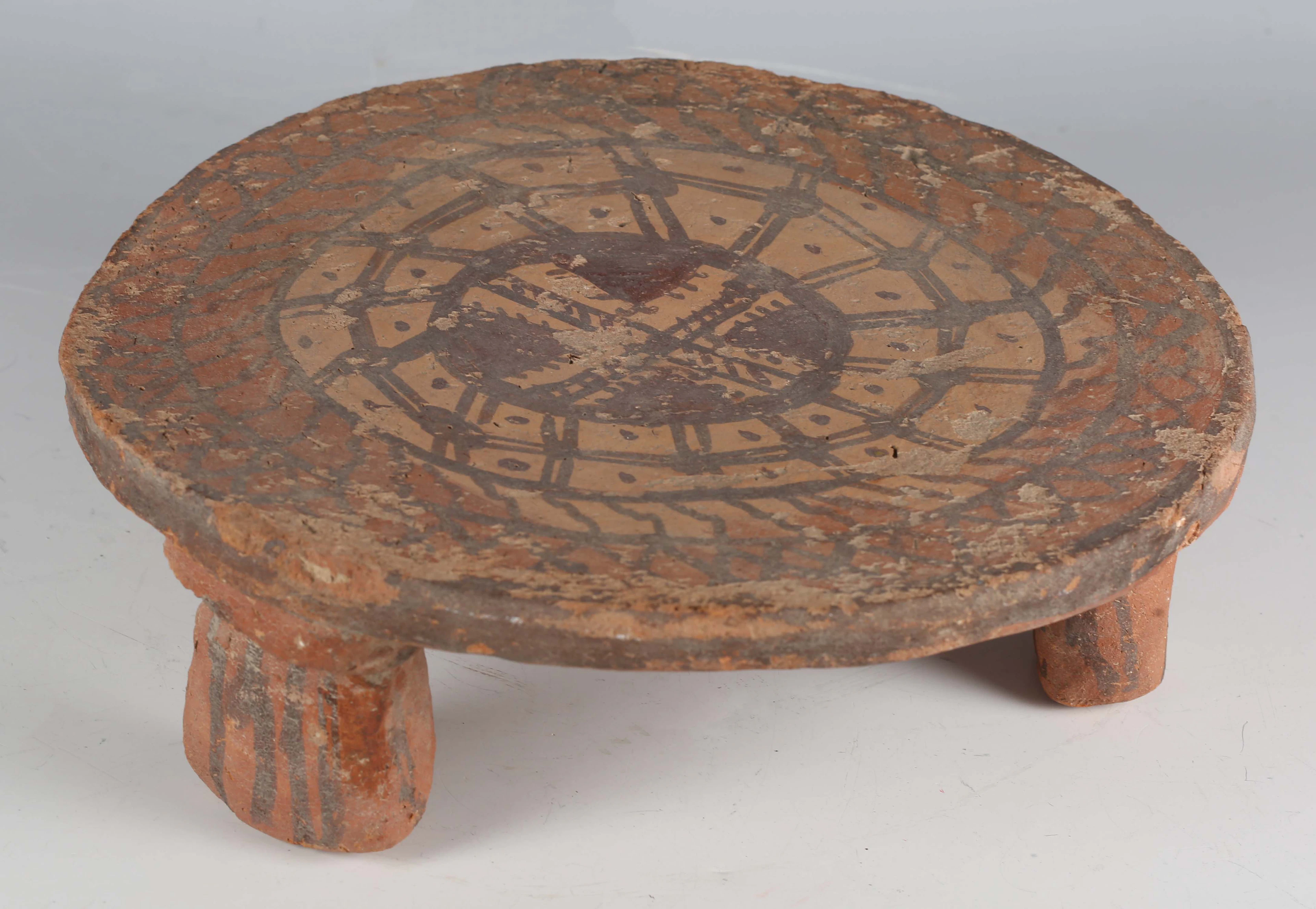 A terracotta circular stand, possibly pre-Columbian, the top with