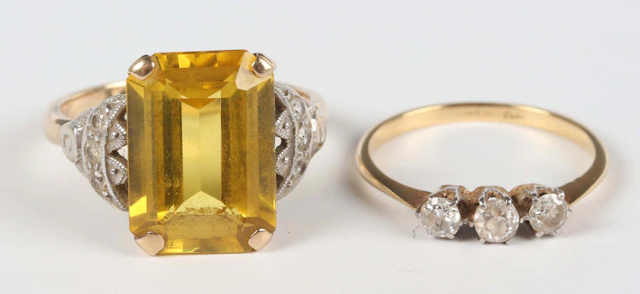 A gold, platinum and diamond three stone ring, claw set with cushion
