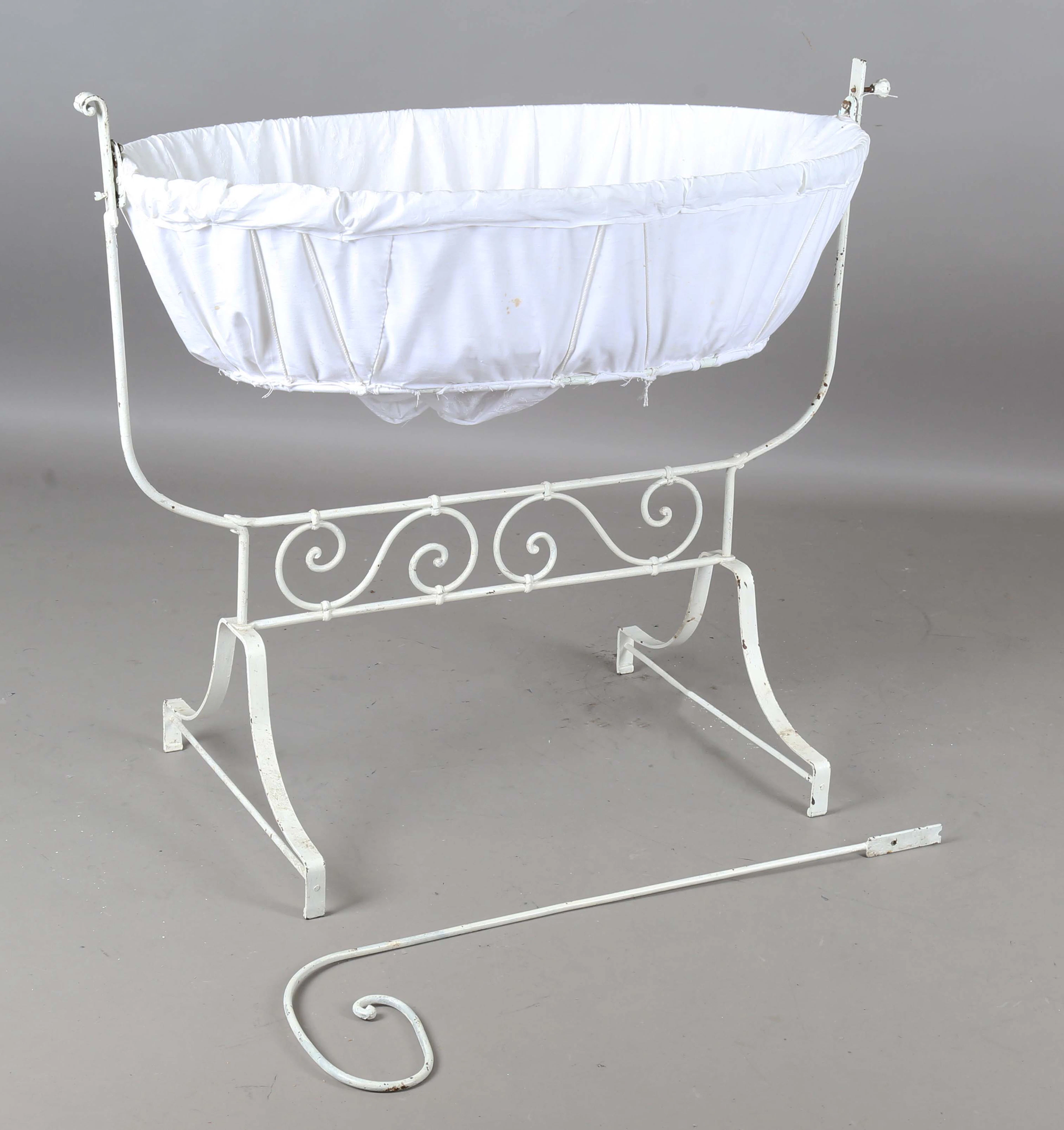 A late Victorian white painted wrought iron rocking crib, length 108cm.