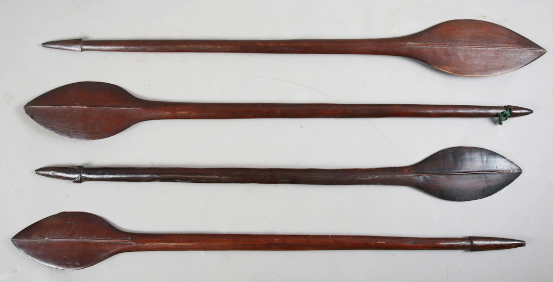 A group of four Pacific Islands hardwood paddle clubs, all with leaf