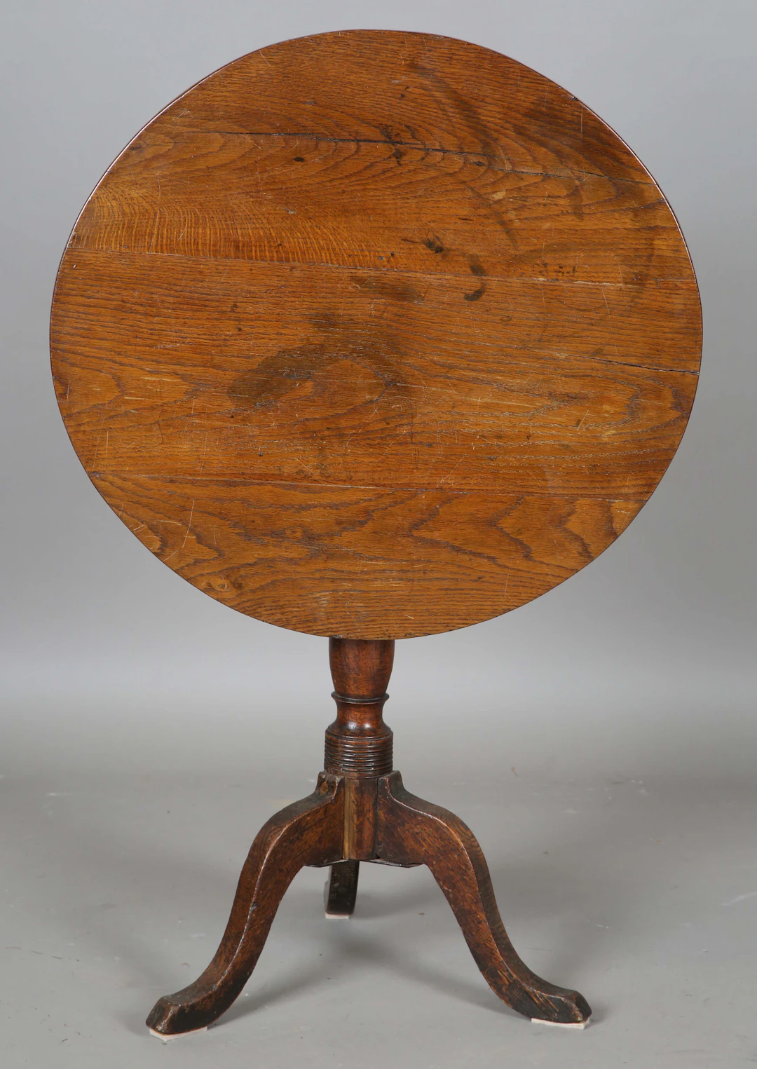 A 19th century provincial oak circular tip-top wine table, on a turned