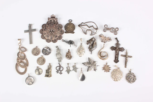 Twenty-eight silver pendants and brooches, including a Navajo style