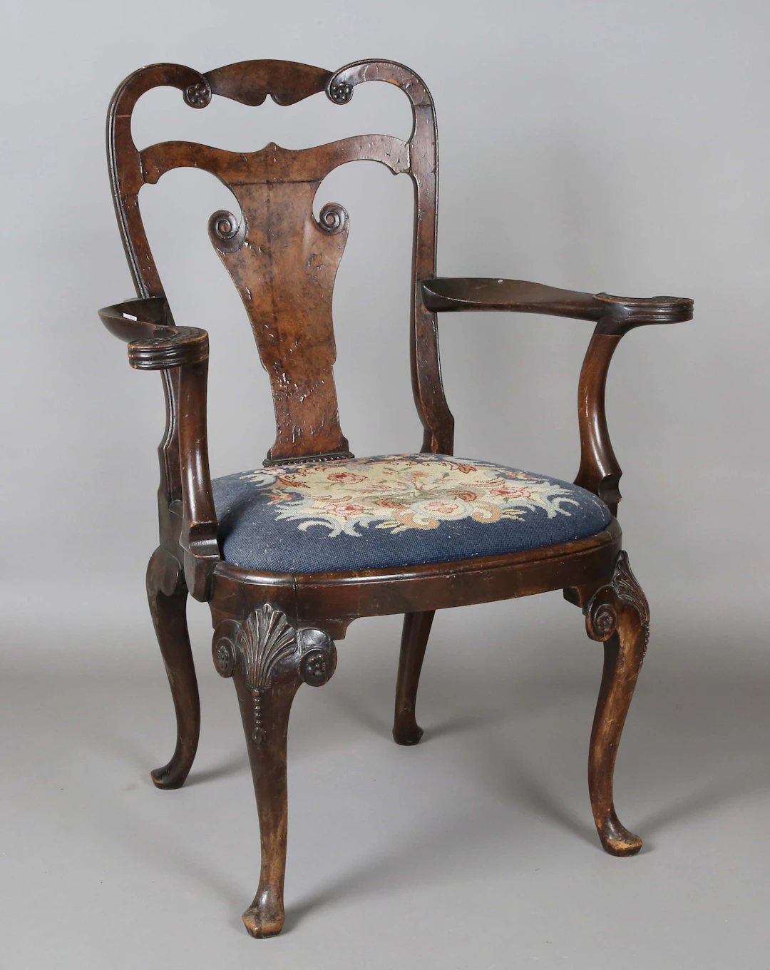 An early 20th century Queen Anne style stained walnut vase back elbow