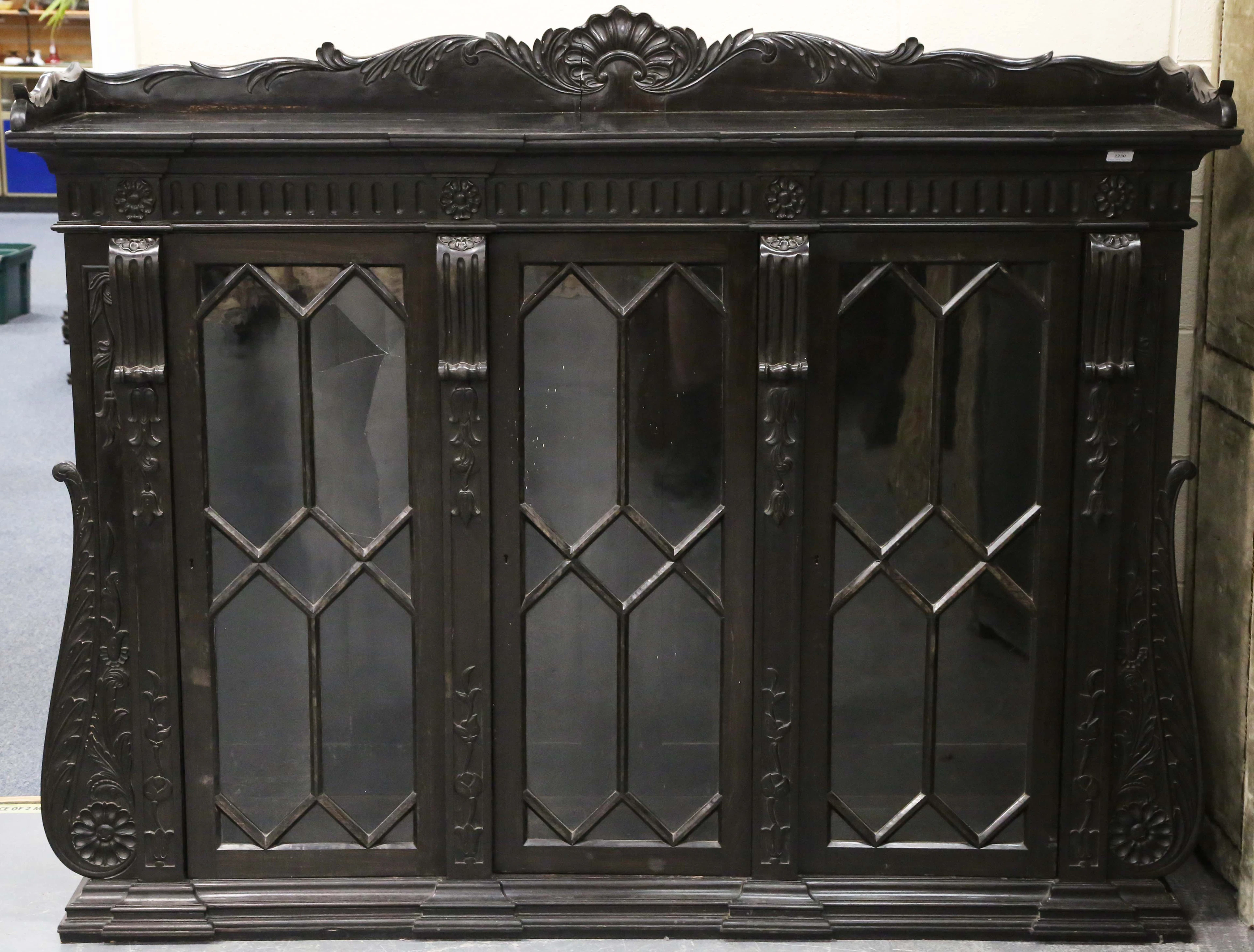 A 19th century Anglo-Indian carved ebony glazed bookcase with a heavily