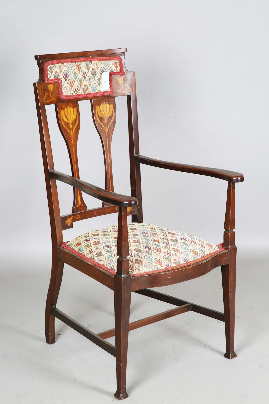 An Edwardian Art Nouveau mahogany framed elbow chair, in the manner